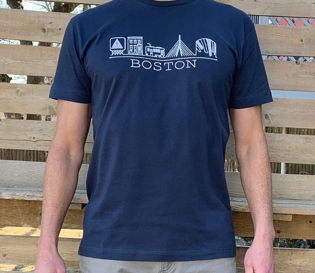 Man wearing dark blue t-shirt with white chest graphic hand drawn illustration of Boston landmarks